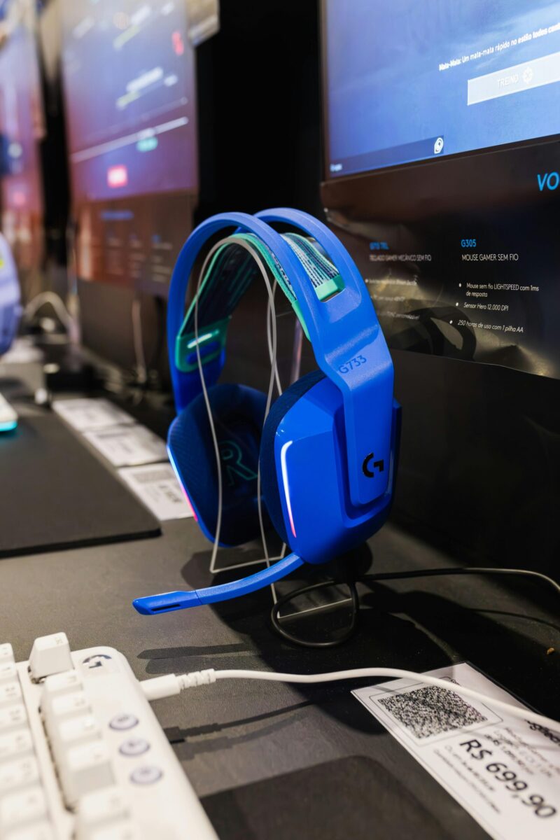 A bright blue wireless gaming headset displayed at an electronics trade show. Ideal for technology enthusiasts.